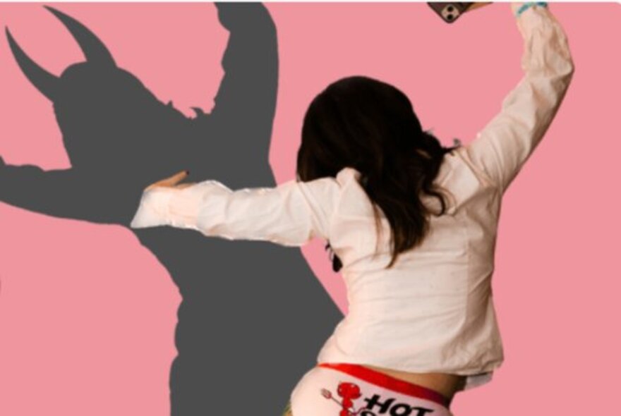 Woman viewed from behind with devil silhouette.
