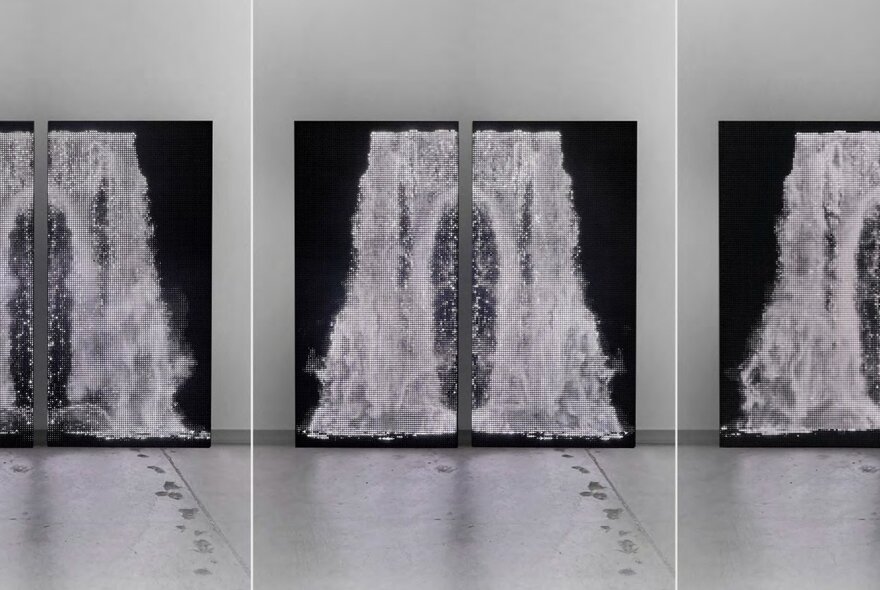 Photographic images of waterfalls displayed in a gallery setting.