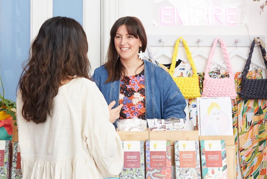 A customer looking at products inside a shop and talking to the retailer.