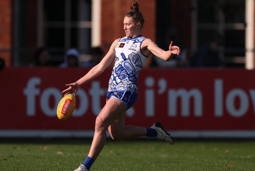 North Melbourne AFW plater mid-kick. 