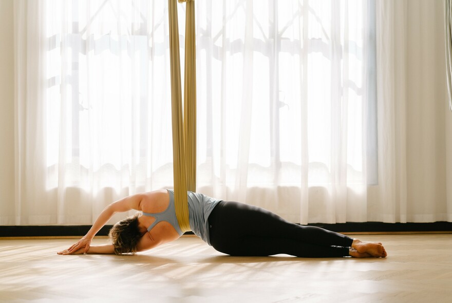 Person doing yoga whilst suspended from the ceiling at Little Mandarin Yoga & Pilates.