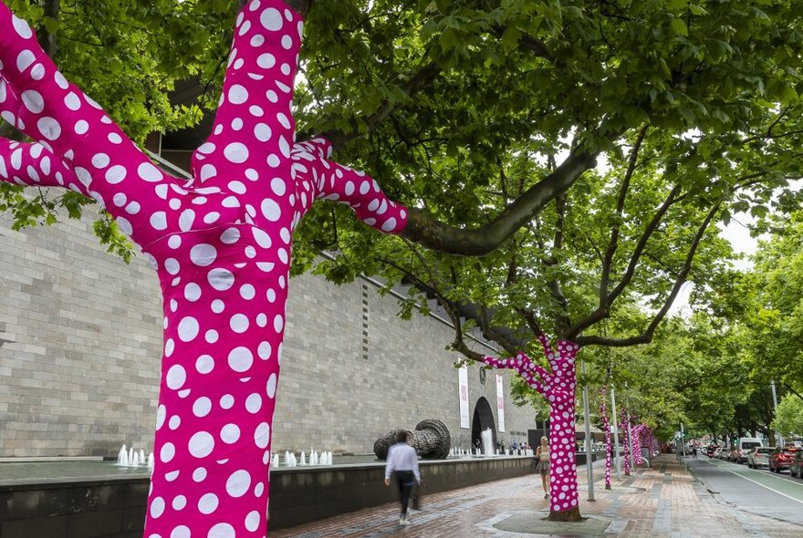 Trees outside NGV International wrapped in pink and white spotted polka dots.