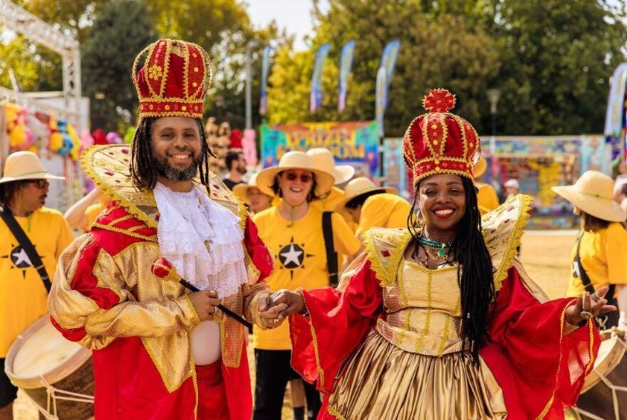 The king and queen of Afro-Brazilian music, wearing gold and red outfits with red velvet crowns.