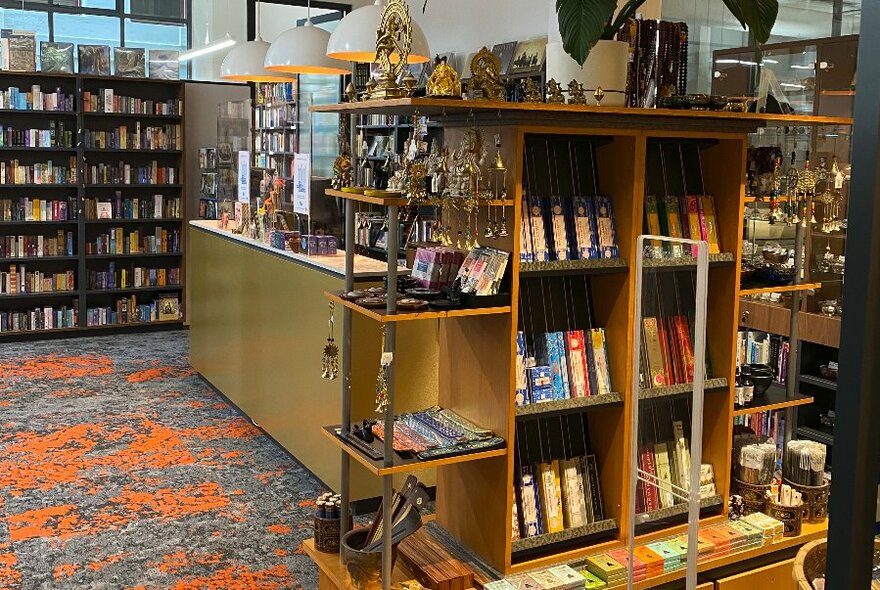 Interior of the TS Bookshop, showing shelves of books and cases with trinkets inside.