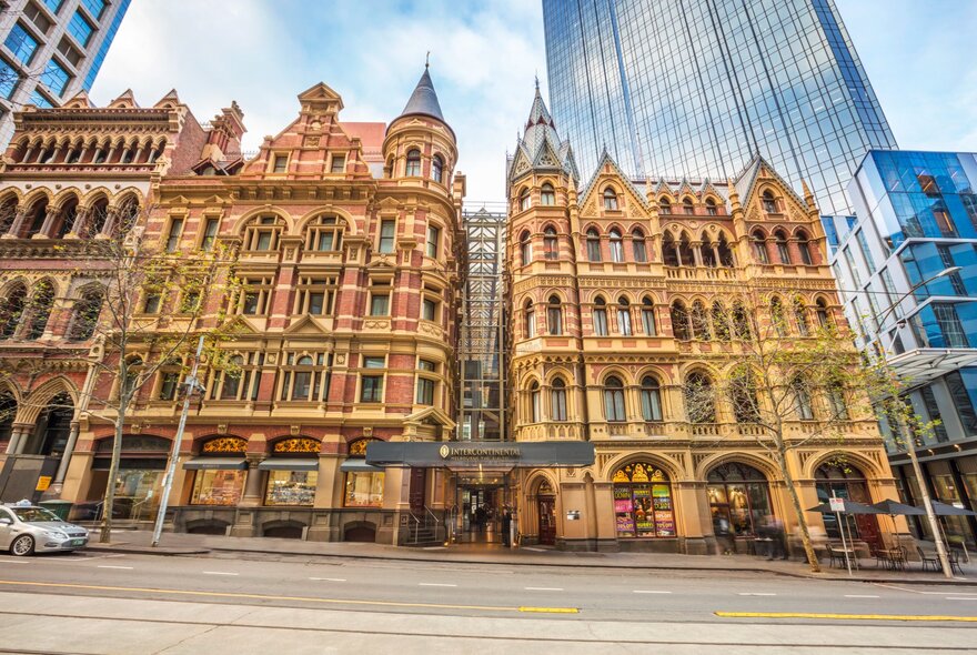 The Neo-Gothic building exterior of the Intercontinental Melbourne at the Rialto, viewed from across the street, with tall buildings in the background.