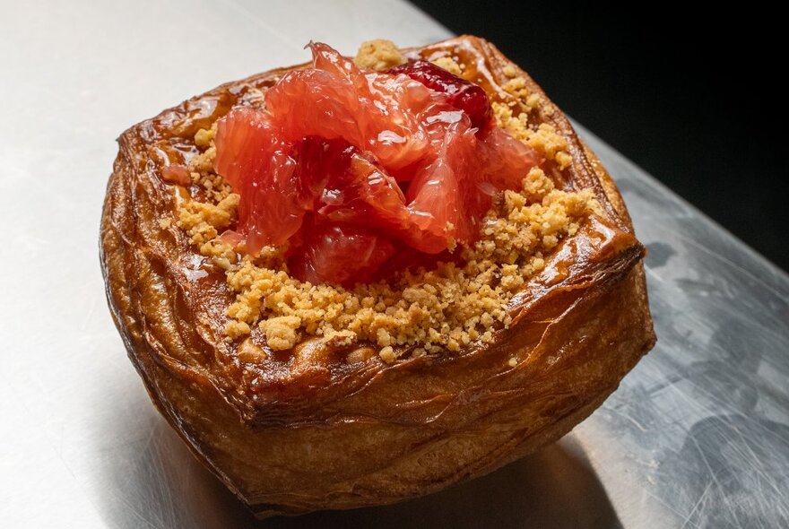 A square pastry with fruit and crumble on top.