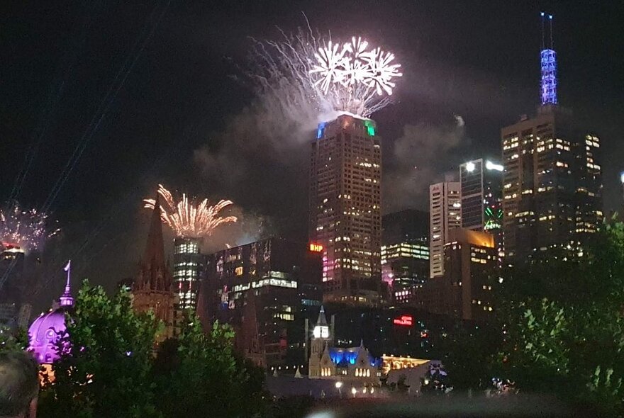 Fireworks in the night sky over Melbourne city skyscrapers, as seen from the balcony at La Camera restaurant.