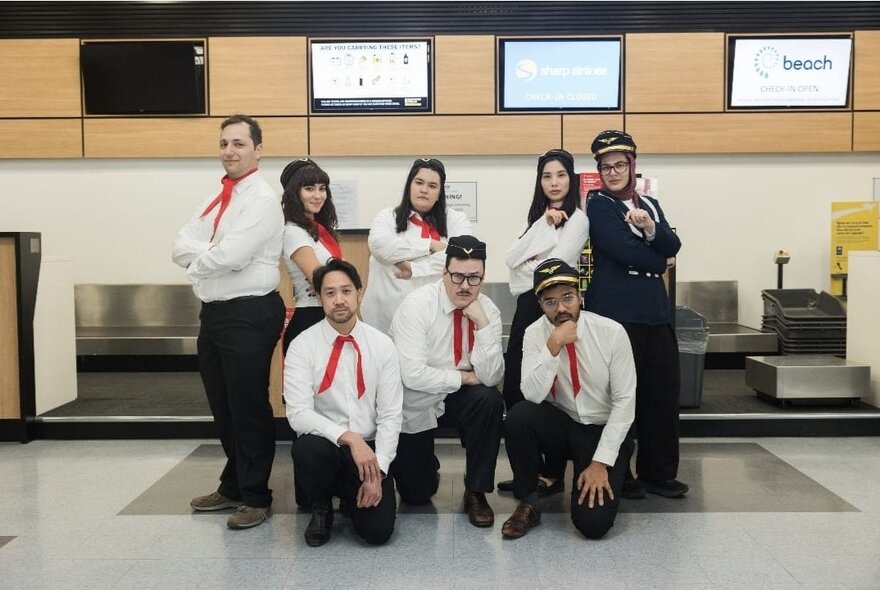 A comedy group posing in uniform for a group shot as migration agents. 