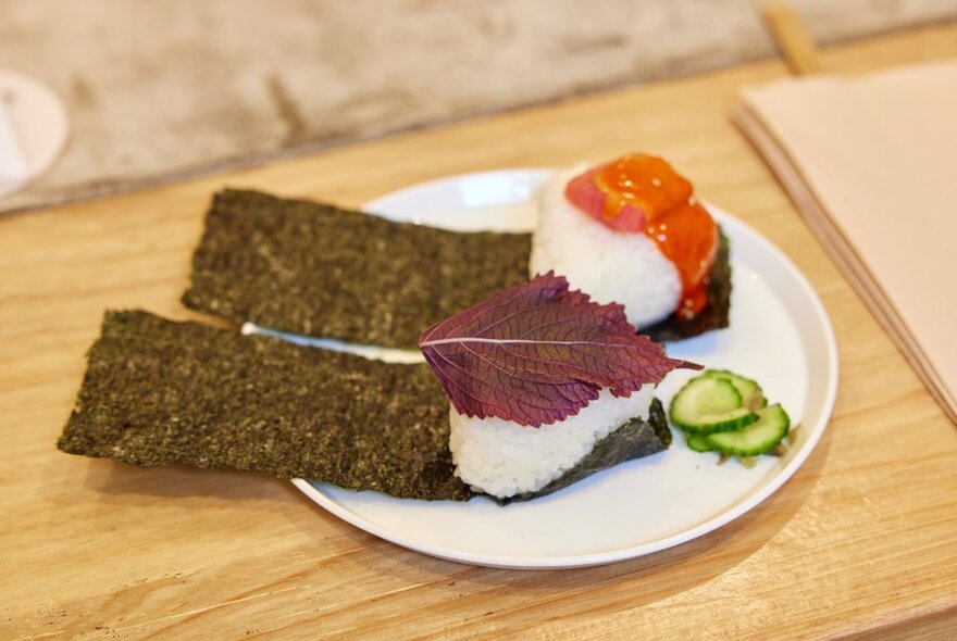 Two open-topped onigiri on a white plate.