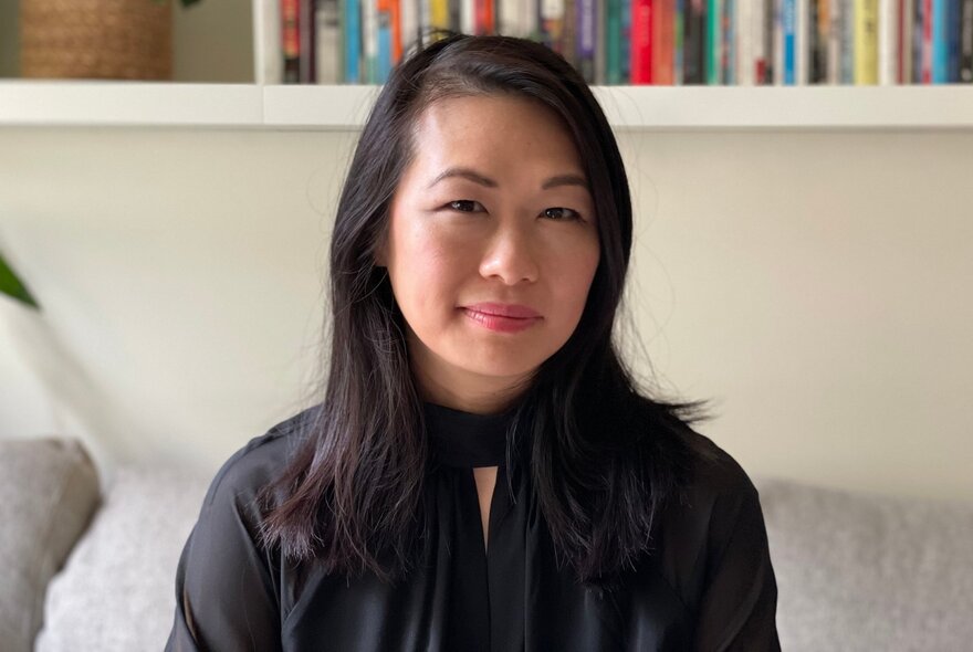 Dr Michelle Lim, a woman with black shoulder length straight hair, wearing a black blouse and smiling slightly at the viewer.