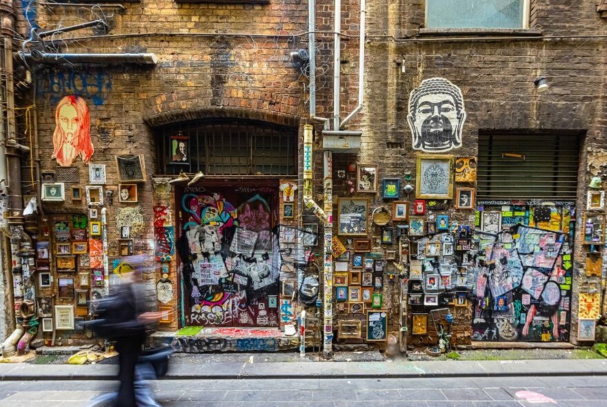 A brick wall covered in tiny frames and artworks.