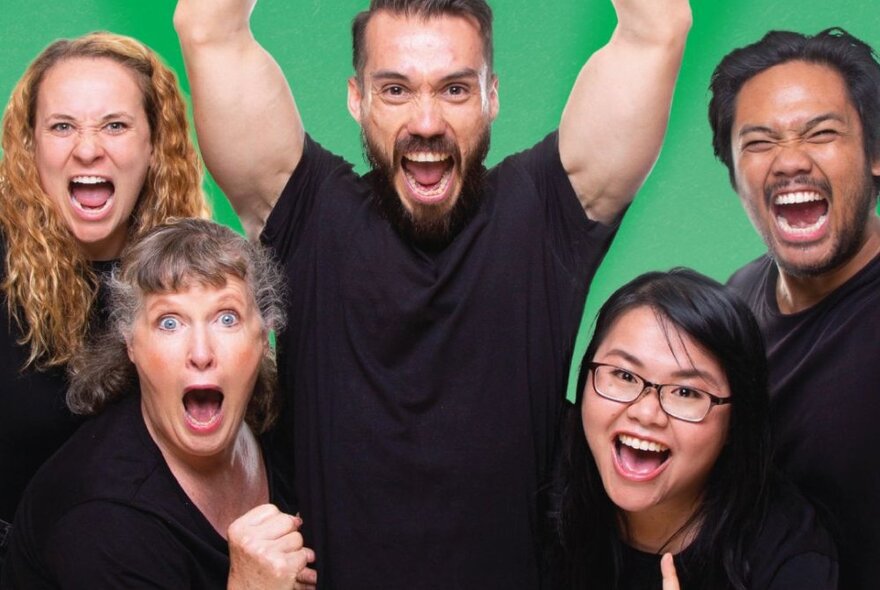 Five actors wearing black t-shirts and making faces and gesticulating with their arms and hands in front of a green backdrop.