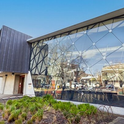 East Melbourne library exterior with large glass-paned facade and porch doorway.