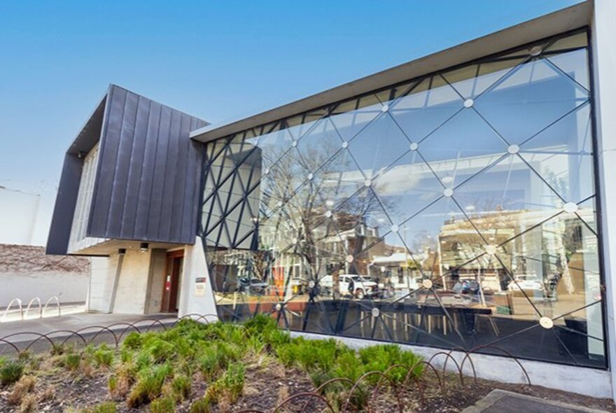East Melbourne library exterior with large glass-paned facade and porch doorway.