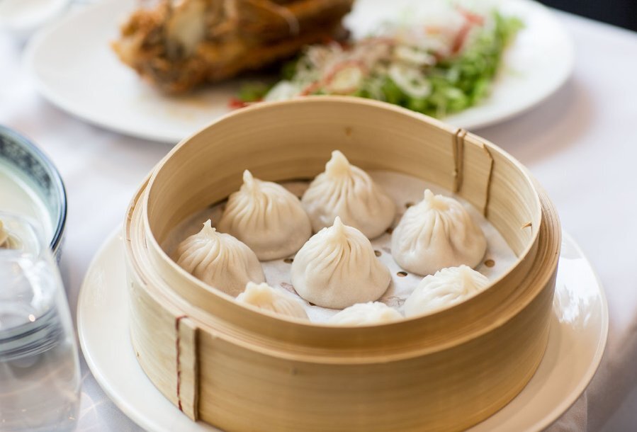 A bamboo basket filled with steamed dumplings.
