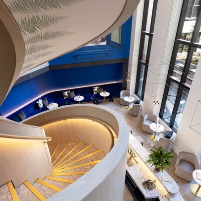 The view down a spiral staircase to a lobby restaurant below.