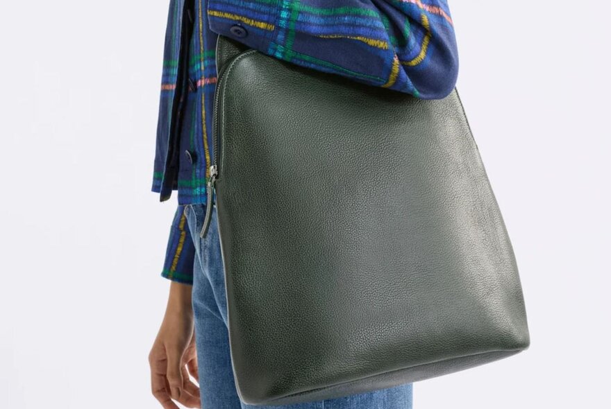 A person is holding a green leather bag
