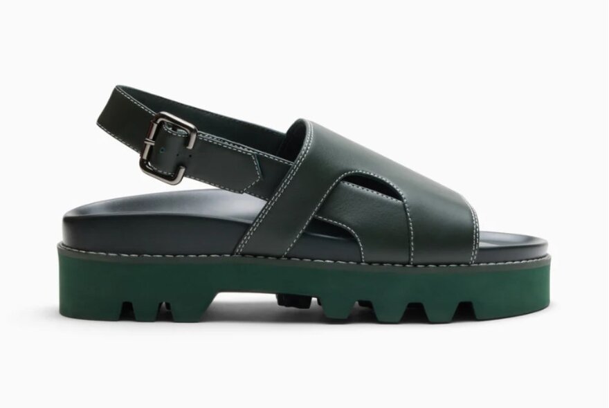 A green sandal with leather straps and a chunky tread.