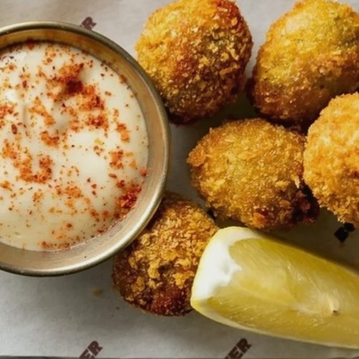 Fried croquettes with dip and lemon slice.