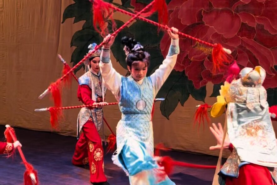 Traditional Taiwanese dancers with red twirling sticks.