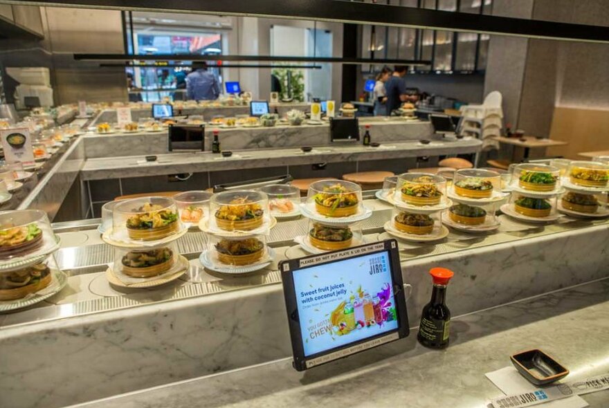 A sushi train conveyor belt in a Japanese restaurant.