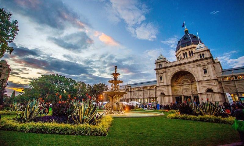 A beautiful building in a garden with a water fountain.