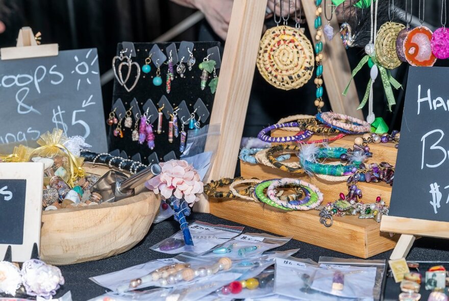 Craft items and jewellery for sale at a market stall.