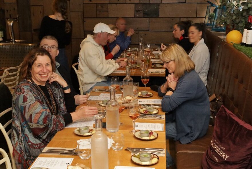 Diners seated at a long table set for dinner.