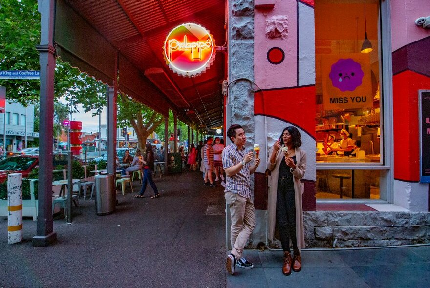 Two people eat ice-cream outside Pidapipo on Lygon Street.