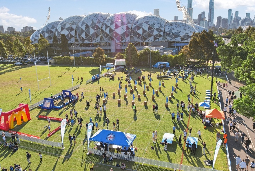 Looking across a soccer pitch at AAMI Park, people on the field casting long shadows.