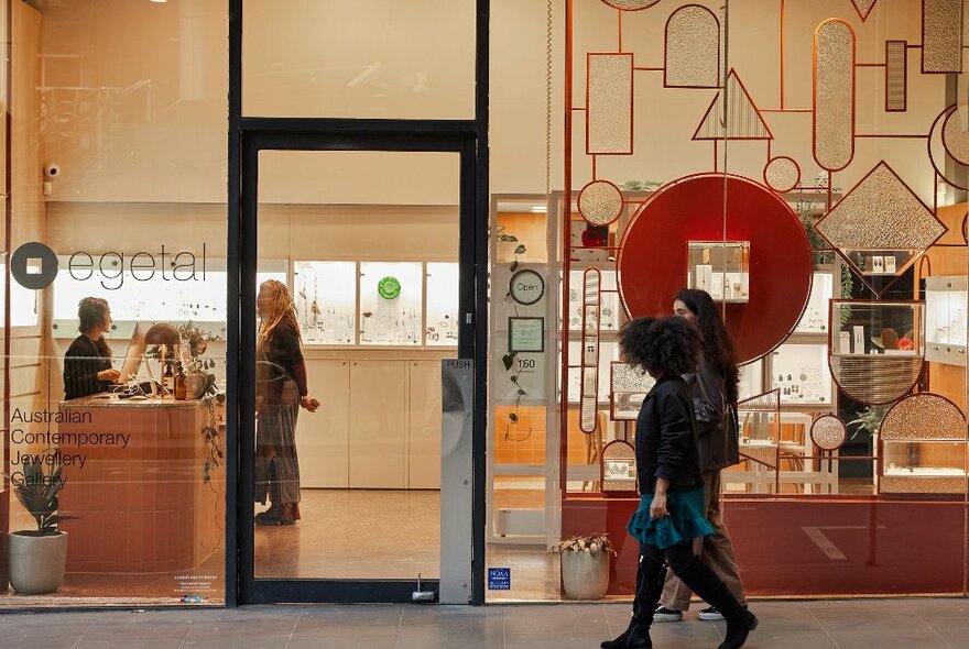 Two friends are walking past a jewellery store