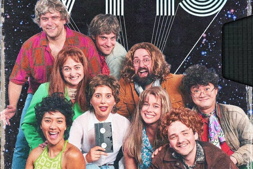 Group of actors in 1970s inspired outfits and wigs smiling and posing.