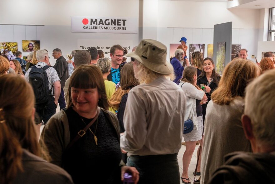 People socialising inside Magnet Galleries at an exhibition's opening launch.