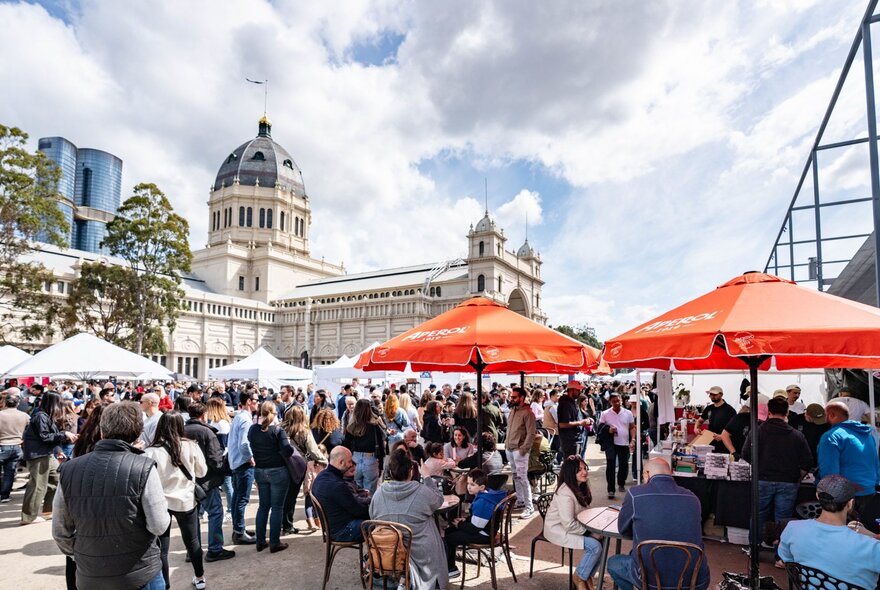A crowd of people and outdoor umbrellas at the Italian festival at the Royal Exhibition Building and Museum Plaza.
