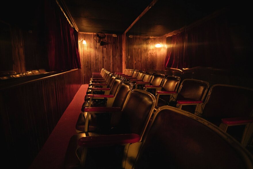 Darkly lit theatre with rows of seating.