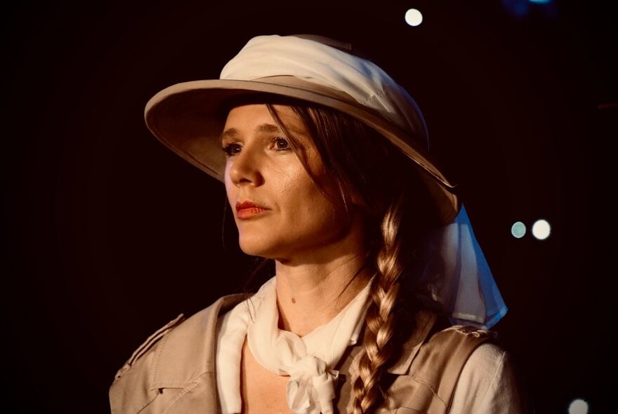 A young woman wearing a 1920s explorer's hat with a thick braid.