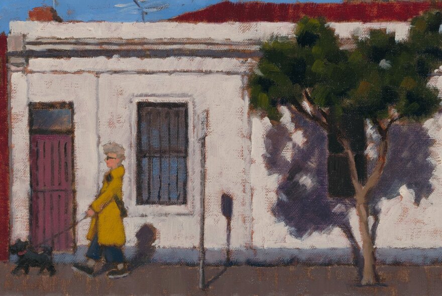 A person walking a dog past an old terrace house and tree in inner Melbourne.