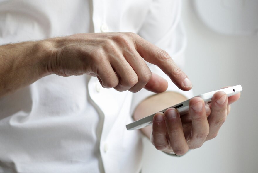 Hands holding a mobile phone, with a finger poised to press.