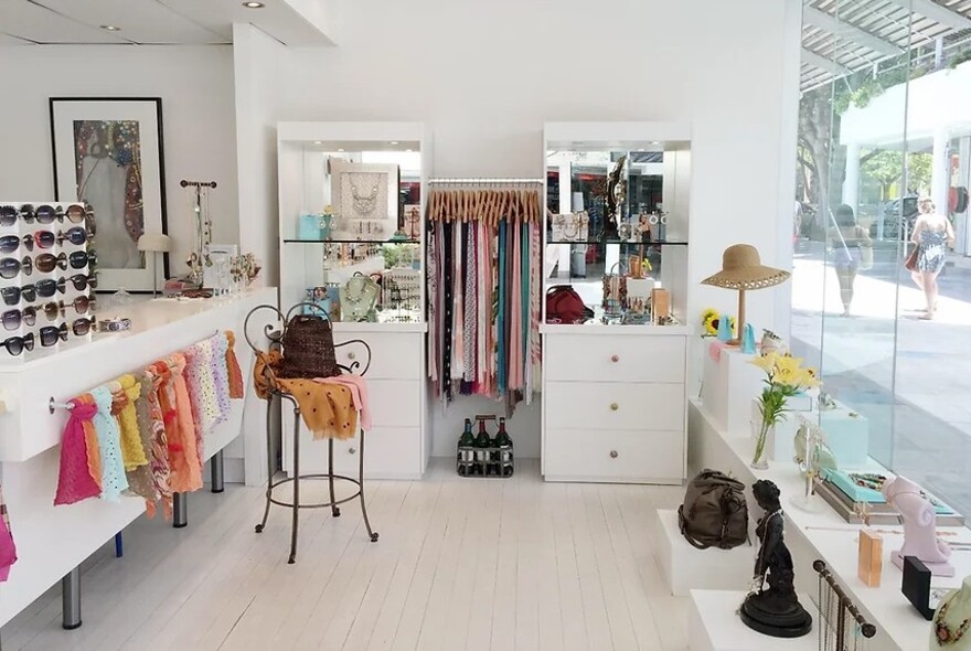 Light, bright shop interior with scarves, sunglasses and hats.