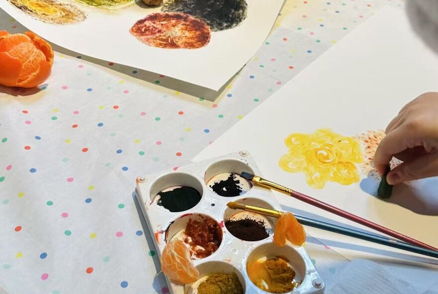 Artworks on paper with brushes and paint palette.