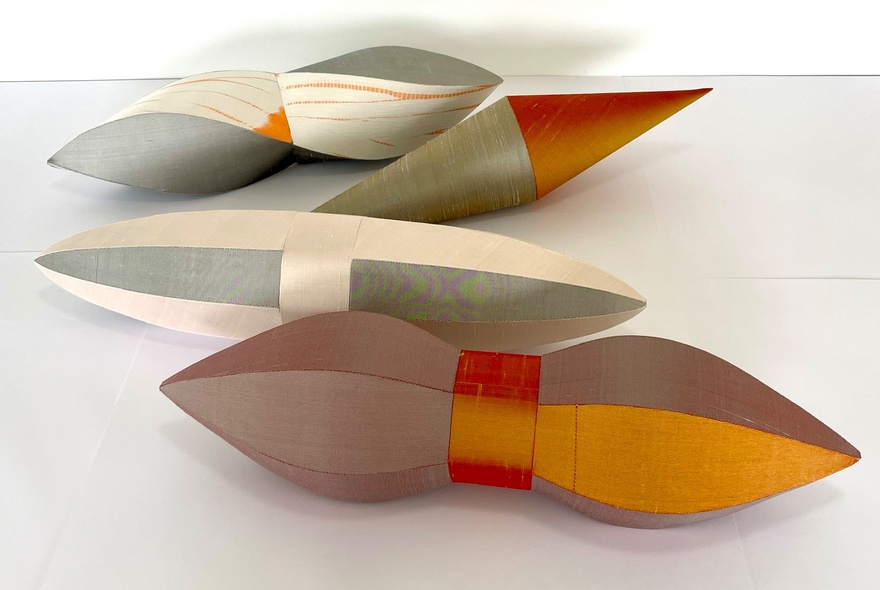Four sculptures in two-tone colours on a white display.