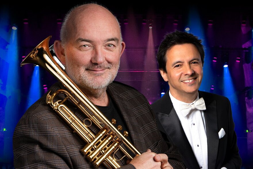 James Morrison, a middle-aged man, smiling and holding a trumpet across his chest, with John Foreman, also a middle-aged man, smiling and wearing a tuxedo with a white shirt and white bow tie. 