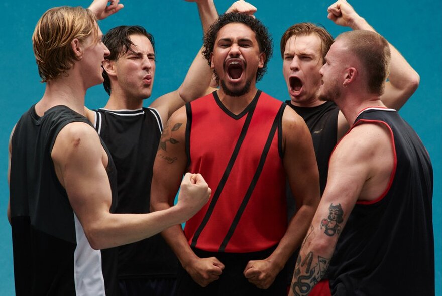 Five actors wearing football jerseys, making fists and yelling.