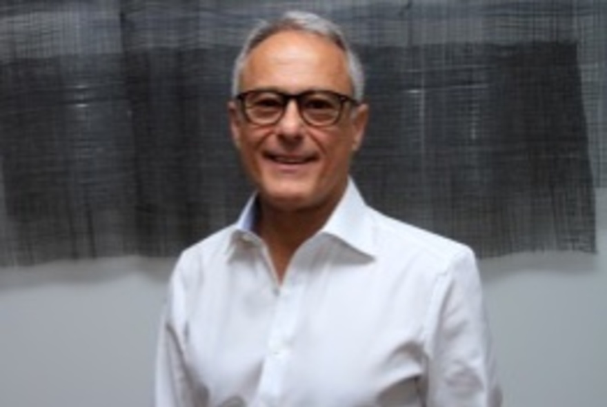 Middle-aged man wearing a white shirt and glasses.