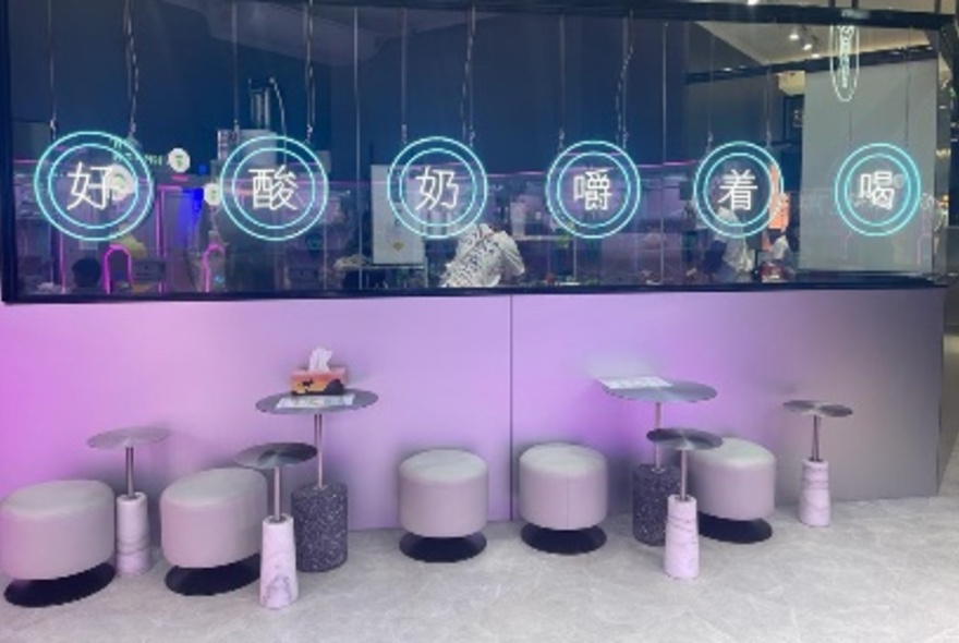 Cafe interior with purple tables and chairs, mirrors.