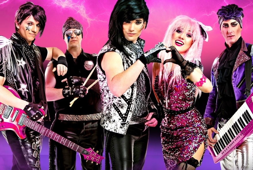 Five musicians dressed in black, purple and pink leather and pink sequinned 80s rocker-style outfits, in front of of a pink and purple background with lightnight strikes.