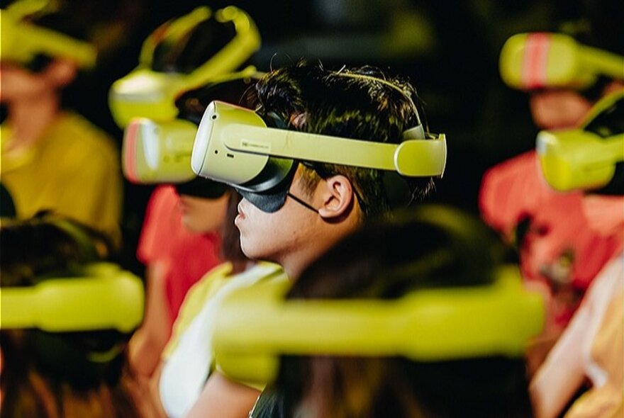 A group of people all wearing green VR headsets.