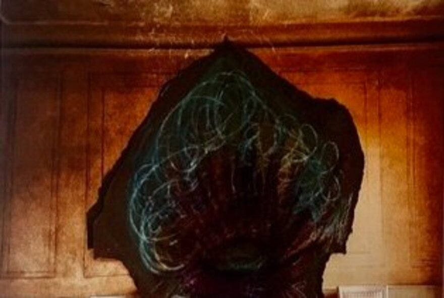 A dark, organic cavernous mass with swirling blue-green lines painted against a panelled wall.