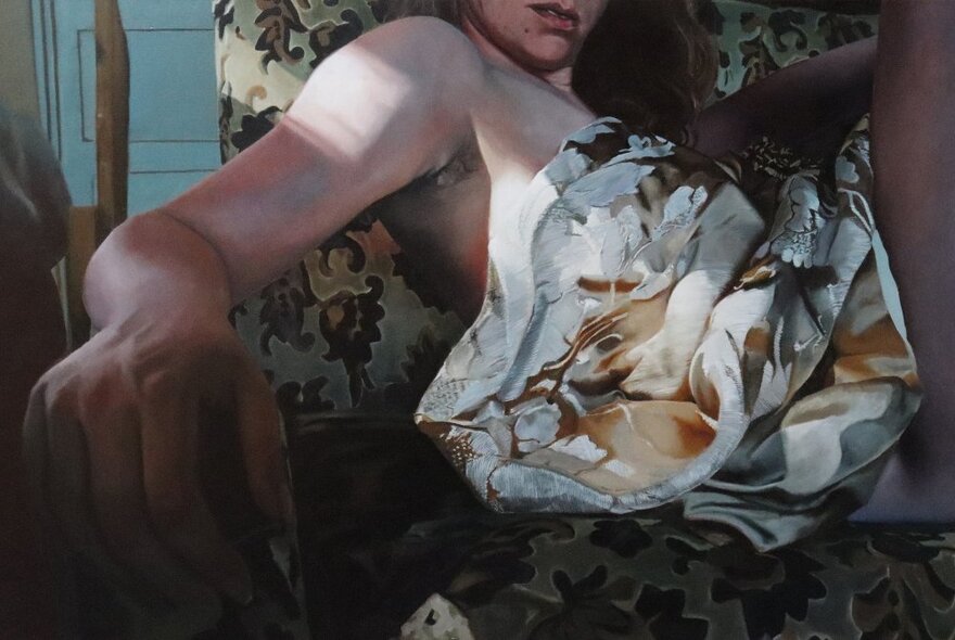 A crop of a painting of a woman sitting in a patterned chair with fabric draped over her, her bare arm and hand a feature of the image. 