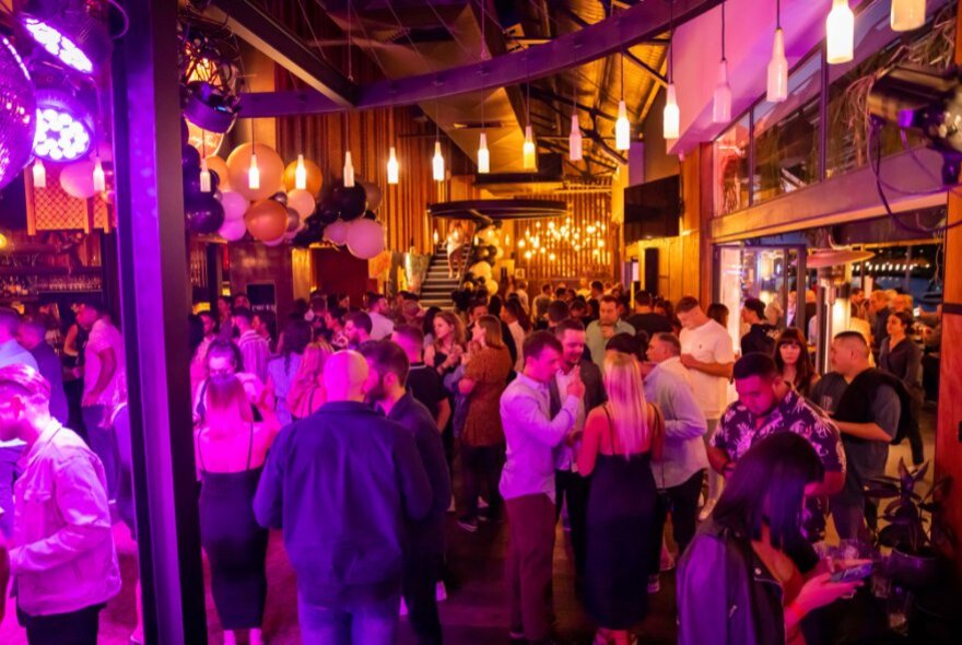 A crowd of people socialising, drinking and celebrating at General Assembly bar.